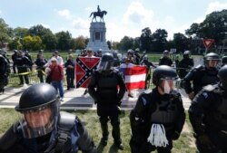 FILE - State Police keep a small group of Confederate protesters separated from counter demonstrators in front of the statue of Confederate General Robert E. Lee on Monument Avenue in Richmond, Virginia, Sept. 16, 2017.