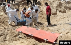 خان یونس کے نصر ہسپتال کے کھنڈرات سے ہنگامی کارکن ہلاک ہونے والے فلسطینیوں کی لاشوں کو نکال کر کسی قبرستان میں منتقل کرنے کےلیےکھدائی کر رہے ہیں۔ فوٹو رائٹرز 21 اپریل 2024