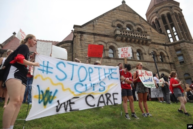 FILE - West Virginia University students lead a protest against cuts to programs in world languages, creative writing and more amid a $45 million budget deficit outside Stewart Hall in Morgantown, W.Va., on Aug. 21, 2023. (AP Photo/Leah Willingham)