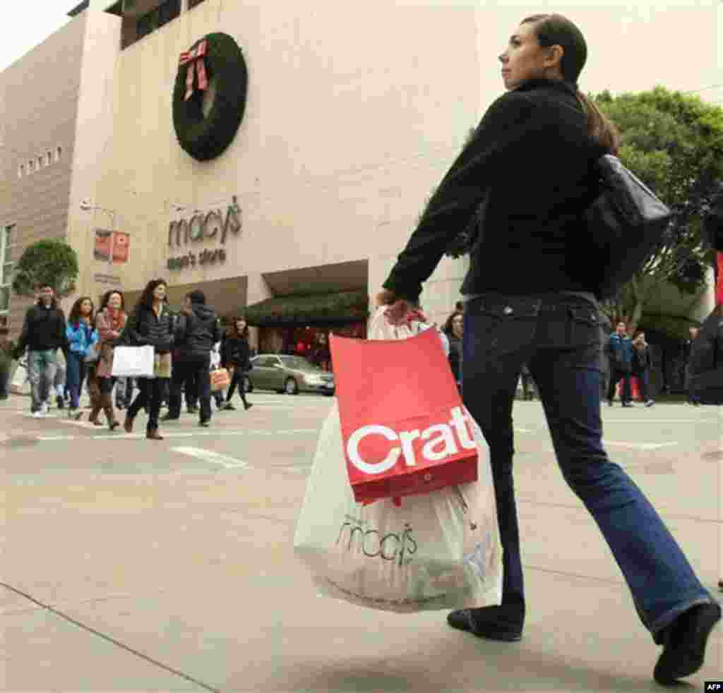 FILE - In this Nov. 25, 2011 file photo, a woman carries shopping bags as she walks near a Macy's store near Union Square in San Francisco. A private research group says consumer�s confidence in the economy in November soared 15 points to its highest leve