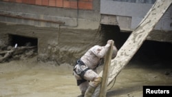 A Volunteer Search and Rescue Service (SAR) member helps in the Inca Llojeta area, which was affected by floodings, in the aftermath of landslides caused by intense rains and illegal earth movements, in La Paz, Bolivia.