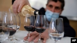 Philippe Darriet, Président of the Institute for wine and vine research and head oenologist fills glasses with wine for a blind tasting at the ISVV Institue in Villenave-d'Ornon, southwestern France, Monday, March 1, 2021. 