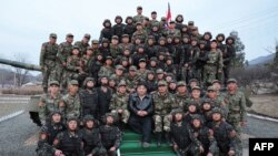 朝中社3月25日公布的照片显示，金正恩（中）3月24日与朝鲜人民军近卫汉城柳京守第105坦克师的士兵们一起拍照留念。