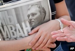 A supporter of Ivan Golunov, an investigative journalist holds a newspaper with texts of his investigations during a protest rally in St. Petersburg, June 12, 2019.