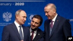 Turkey's President Recep Tayyip Erdogan, right and Russia's President Vladimir Putin, left, talk after they symbolically open a valve during a ceremony in Istanbul for the inauguration of the TurkStream pipeline, Jan. 8, 2020. 