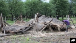 FILE: A young boy shows a hut that was destroyed by floods in Tsholostho, about 200 kilometers north of Bulawayo.