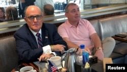 El abogado Rudolph Giuliani (izq.) comparte en un café con el empresario ucraniano Lev Parnas, en el Trump International Hotel in Washington DC, en septiembre de 2019.