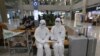 Chonnam National University staff wearing protective attire are on standby for special transportation for Chinese students studying at their university, at Incheon International Airport in Incheon, South Korea, Feb. 25, 2020.