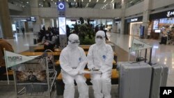 Chonnam National University staff wearing protective attire are on standby for special transportation for Chinese students studying at their university, at Incheon International Airport in Incheon, South Korea, Feb. 25, 2020.