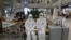 Chonnam National University staff wearing protective attire are on standby for special transportation for Chinese students studying at their university, at Incheon International Airport in Incheon, South Korea, Feb. 25, 2020.