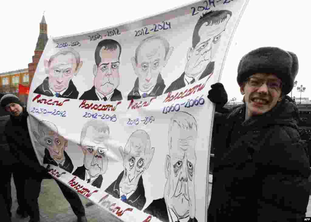 Supporters of the Russian communist party hold a banner displaying caricatures of President Dmitry Medvedev and Prime Minister Vladimir Putin during a rally to protest against violations at the parliamentary elections and the policies conducted by Russian