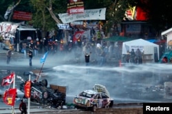 FILE - Riot police fire a water cannon on Gezi Park protesters at Taksim Square in Istanbul, Turkey, June 15, 2013.