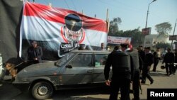 Des officiers de police égyptiens inspectent une voiture, au Caire, le 25 janvier 2014. 