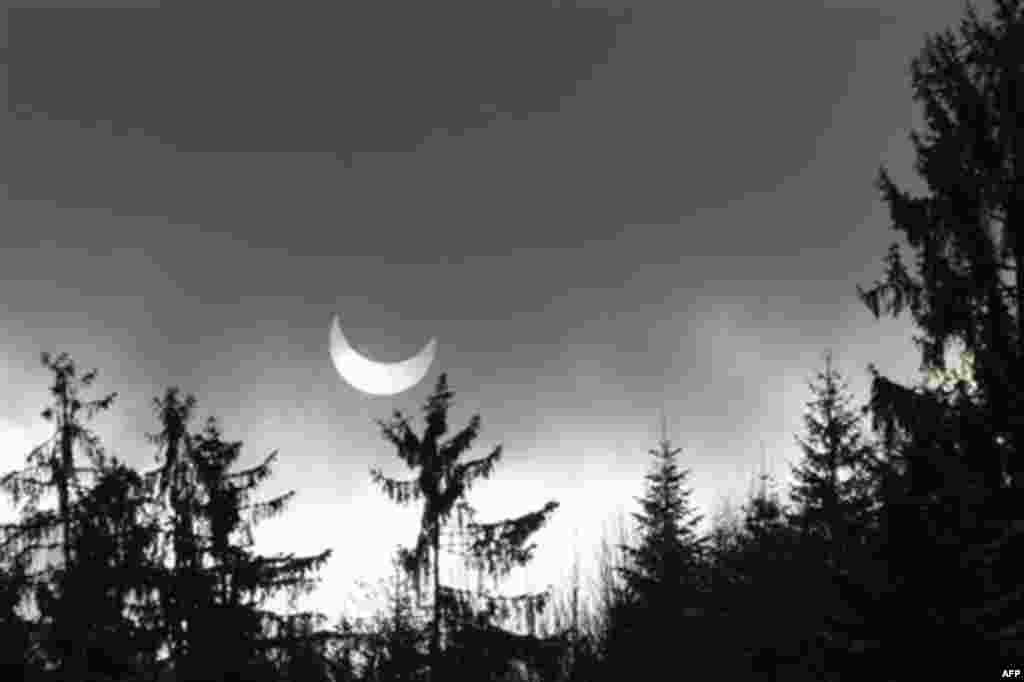 A partial solar eclipse is seen through clouds and snow flurries near Sarajevo, Bosnia , on Tuesday, Jan. 4, 2011. A partial solar eclipse began Tuesday in the skies over the Mideast and will extend across much of Europe. (AP Photo/Amel Emric)