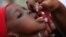FILE - An unidentified health official administers a polio vaccine to a child in Kawo Kano, Nigeria, April. 13, 2014.