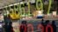 FILE - People wait to cross the street in front of an electronic stock indicator in Tokyo.