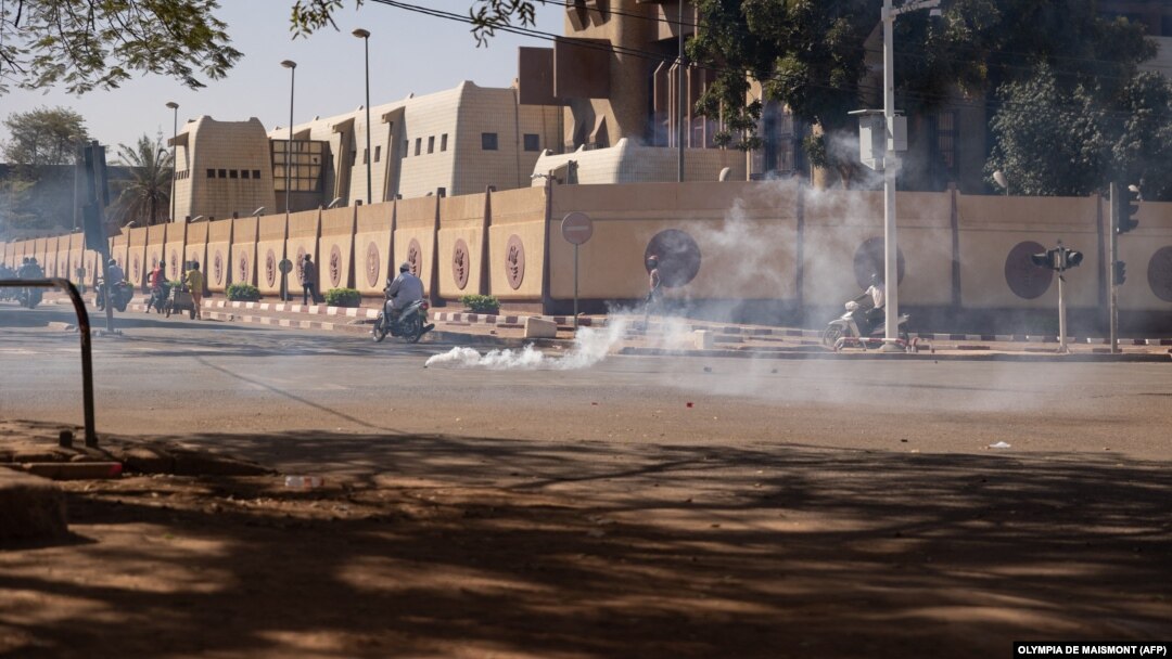 Pasukan keamanan menembakkan gas air mata untuk membubarkan massa yang mendukung militer di Ouagadougou, Burkina Faso, Minggu (23/1). 
