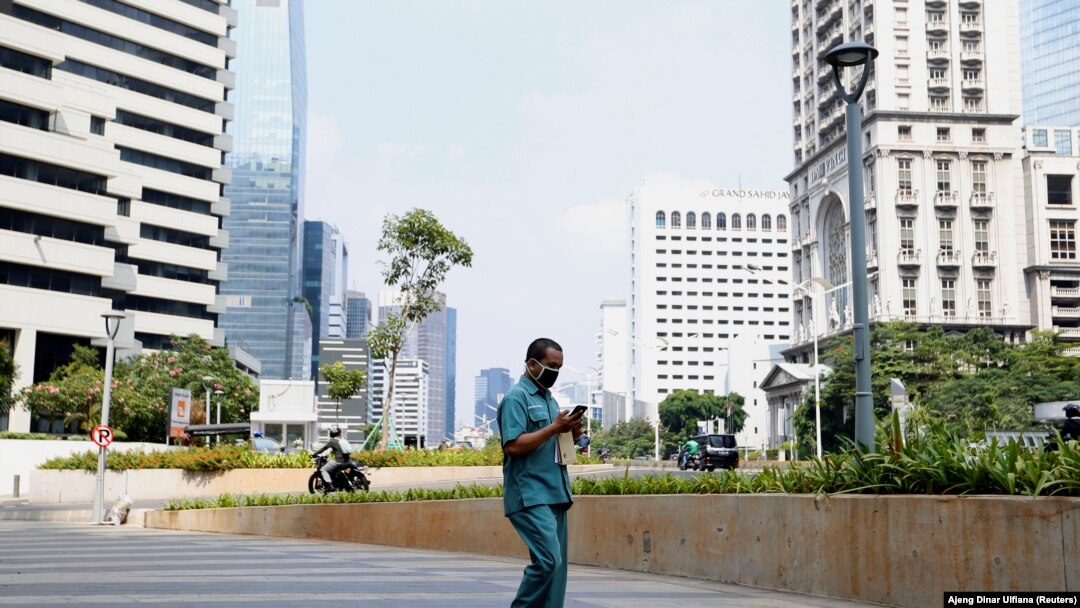 Seorang pria mengenakan masker pelindung wajah, berjalan di kawasan bisnis, Jakarta, Indonesia, 8 Juni 2020. (Foto: REUTERS/Ajeng Dinar Ulfiana)