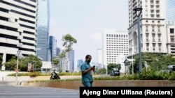 Seorang pria mengenakan masker pelindung wajah, berjalan di kawasan bisnis, Jakarta, Indonesia, 8 Juni 2020. (Foto: REUTERS/Ajeng Dinar Ulfiana)