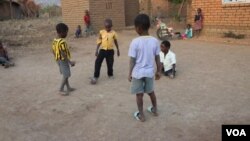 Talandira (in white shirt) plays soccer with friends. (Lameck Masina/VOA)