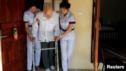 Wolfgang, 96, from Switzerland is helped to walk by two nurses, while staying at the Care Resort in Chiang Mai, Thailand April 6, 2018.
