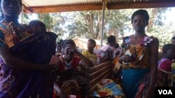 FILE - Some women in Malawi have had their uteruses involuntarily removed soon after giving birth in procedures that have come under scrutiny. Pictured here are mothers attending a clinic with their children the at Likuni clinic in the capital Lilongwe.