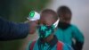 FILE - A boy's temperature is checked as he enters a school amid the coronavirus pandemic, in Johannesburg, South Africa, July 7, 2020.