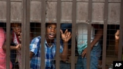 Seorang anak menunggu bersama anak-anak lain di dalam area kantor Komisi Bantuan Pengungsi Meksiko, sementara orang tua mereka mengisi dokumen, di Tapachula, Meksiko, 26 April 2019. (Foto: AP)