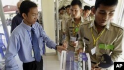 A Cambodian court spokesman Huy Vannak, left, delivers court documents at the court entrance of the U.N.-backed war crimes tribunal in Phnom Penh, Cambodia, Tuesday, Nov. 22, 2011. Pol Pot's close confederates cannot solely blame their late leader for th