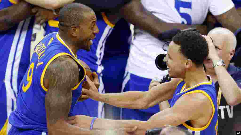 Stephen Curry (30) à droite, et Andre Iguodala (9) de Golden State Warriors célèbrent après avoir remporté le 6e match de la finale de basket-ball de la NBA face à Cleveland, mardi 16 Juin, 2015.