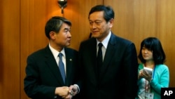 Japan's Vice Minister for Foreign Affairs Akitaka Saiki, right, shakes hands with his South Korean counterpart Cho Tae-yong before their meeting at the Foreign Ministry in Seoul, Wednesday, March 12, 2014.