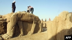 Iraqi workers clean a winged-bull statue at an archeological site in Nimrud. (File)