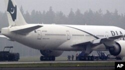 Two anti-terrorist policemen (C) secure one of the passengers as a Pakistan International Airlines Boeing 777 is evacuated at Stockholm Arlanda International airport, 25 Sep 2010