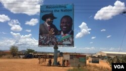 Sebuah papan (billboard) di ibukota Sudan Selatan, Juba, menampilkan gambar Presiden Sudan Selatan Salva Kiir (kiri), dan pemimpin pemberontak Riek Machar (kanan), 15 April 2016 (Foto: VOA/J. Patinkin)