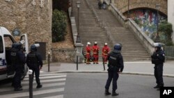 Agentes de policía y rescatistas aguardan por instrucciones en las afueras del consulado iraní, el viernes 19 de abril de 2024 en París.
