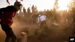 Kurds cover the grave of Ahmed Mustafa, a People's Protection Units (YPG) fighter, who died after being injured while fighting the Islamic State forces in the Syrian city of Kobani, during his funeral in Suruc, on the Turkey-Syria border, Nov. 12, 2014. 