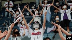 Fans wearing face masks to help protect against the spread of the new coronavirus cheer during the KBO league game between Doosan Bears and LG Twins in Seoul, South Korea, July 27, 2020.