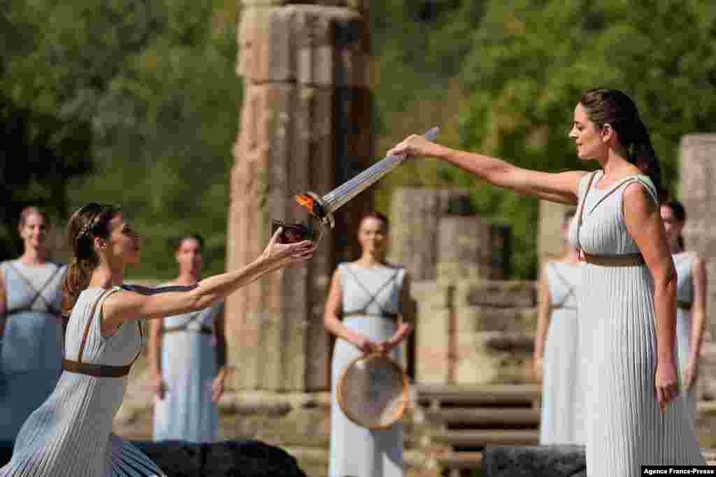 Greek actress Xanthi Georgiou, playing the part of the High Priestess, lights the torch during the flame lighting ceremony for the Beijing 2022 Winter Olympics at the Ancient Olympia archeological site, birthplace of the ancient Olympics in southern Greece.