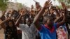 People displaced following attacks by Islamist militants raise their arms as they pass through security before casting their votes, in Yola, Nigeria, March 28, 2015.