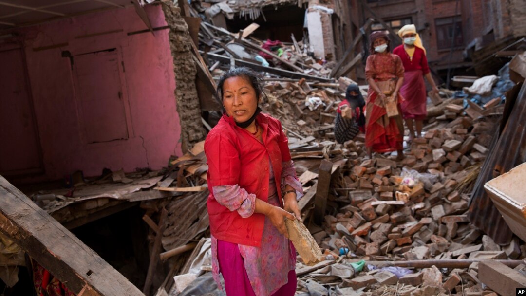 Warga berusaha mencari barang-barang di antara reruntuhan rumahnya akibat gempa di Bhaktapur, Nepal (3/5). (AP/Bernat Amangue)