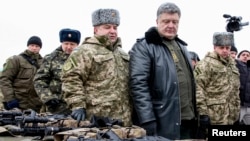 Ukrainian President Petro Poroshenko (2nd R) inspects military hardware as he visits the Yavoriv military range outside Lviv, western Ukraine, Dec. 30, 2014.