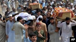 People carry the coffins of the victims of a suicide bombing at an election rally for burial in Peshawar, Pakistan, July 11, 2018. The Pakistani Taliban claimed responsibility for an overnight suicide bombing at a rally that killed a secular politician and 20 others two weeks before nationwide elections.