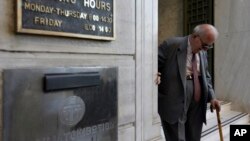 一名希腊老人走出雅典的希腊国家银行分支的大门。（2015年7月20日）