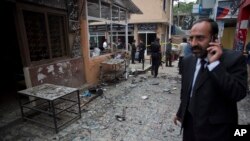 A lawyer talks on his mobile phone at the site of a suicide attack in a court complex, Islamabad, March 3, 2014.