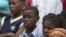 Children watch Haiti's President Michel Martelly visit their camp for people who were displaced by the 2010 earthquake on Aug. 24, 2012. 