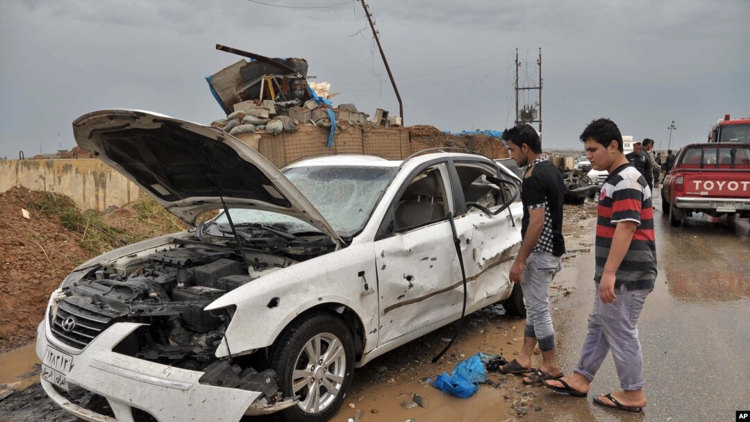 Warga Irak memeriksa lokasi ledakan bom mobil bunuh diri di barat laut kota Kirkuk, 13 April 2014. 