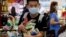 A man wearing a protective mask looks for the start of the queue at a grocery store in Taguig, metropolitan Manila, Philippines on Friday, March 13, 2020. Many people trooped to supermarkets and stocked up on supplies as the Philippine president announced