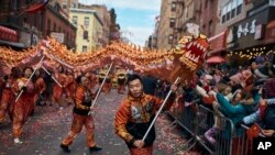 A member of a dragon dance group carries the head of the dragon during the Chinese Lunar New Year parade in Chinatown in New York, Sunday, Feb. 17, 2019.