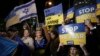 People hold placards as they take part in a protest against the Russian invasion of Ukraine, outside Israel's governments office in Tel Aviv, Israel, March 12, 2022. 