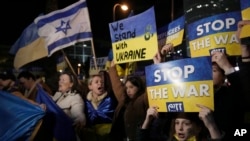 People hold placards as they take part in a protest against the Russian invasion of Ukraine, outside Israel's governments office in Tel Aviv, Israel, March 12, 2022. 